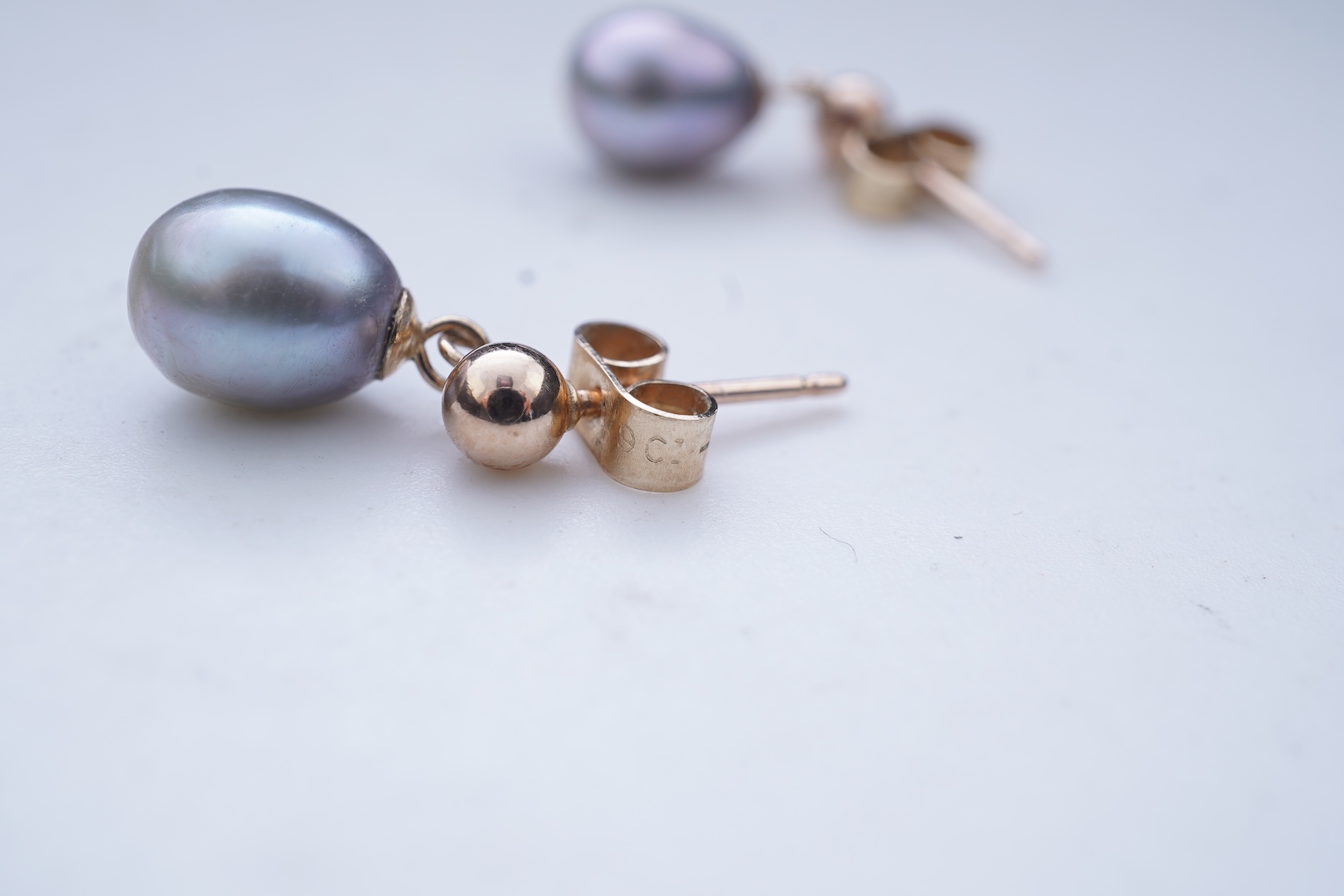 A group of cultured pearl jewels, comprising: two pairs of cultured pearl drop earrings, longest 3cm, mounted in gold; and two cultured pearl brooches mounted in 9ct gold, longest 4.1cm, British hallmarks, combined gross